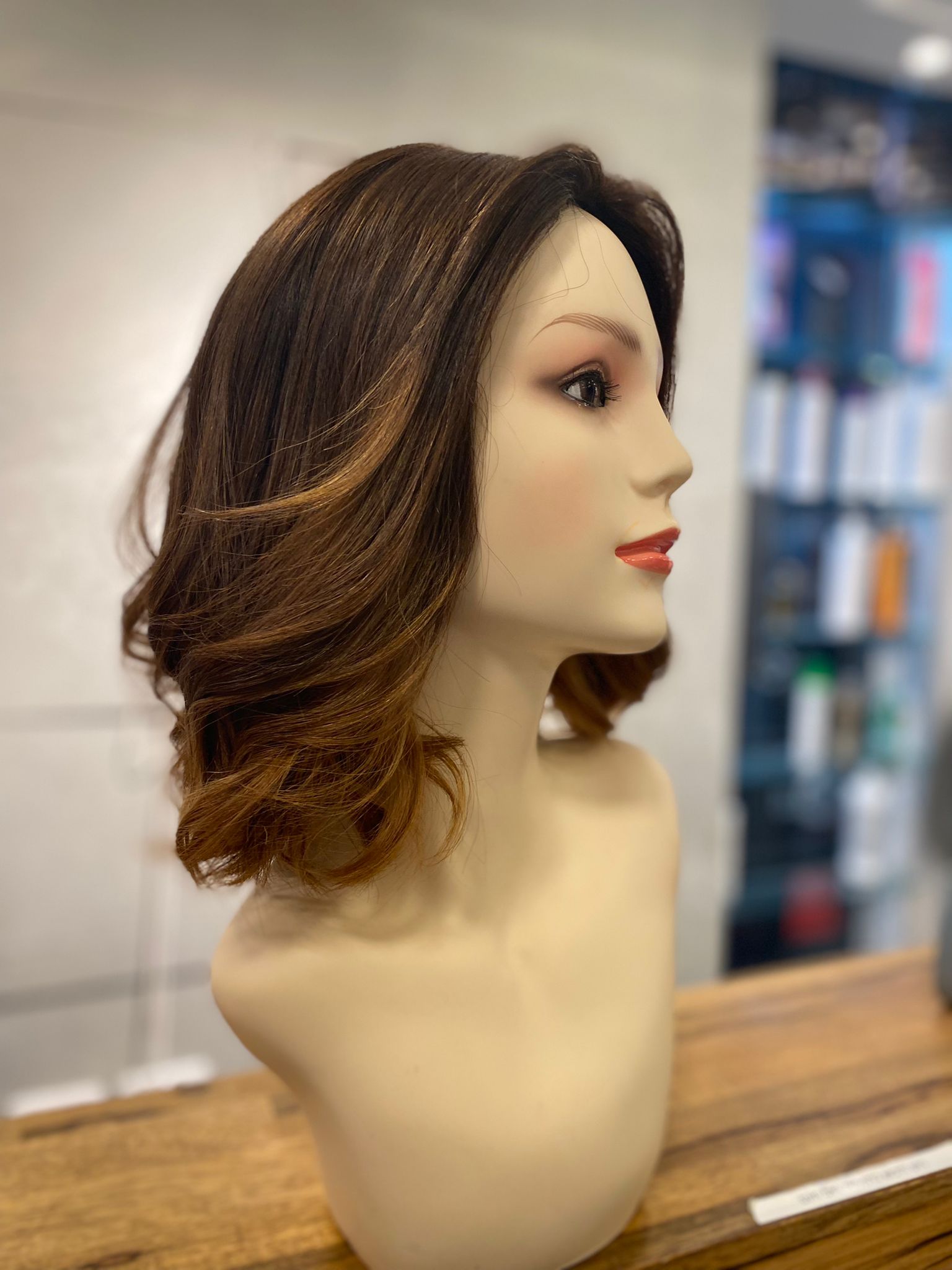 Une perruque en cheveux naturels de longueur moyenne sur une tête de présentation