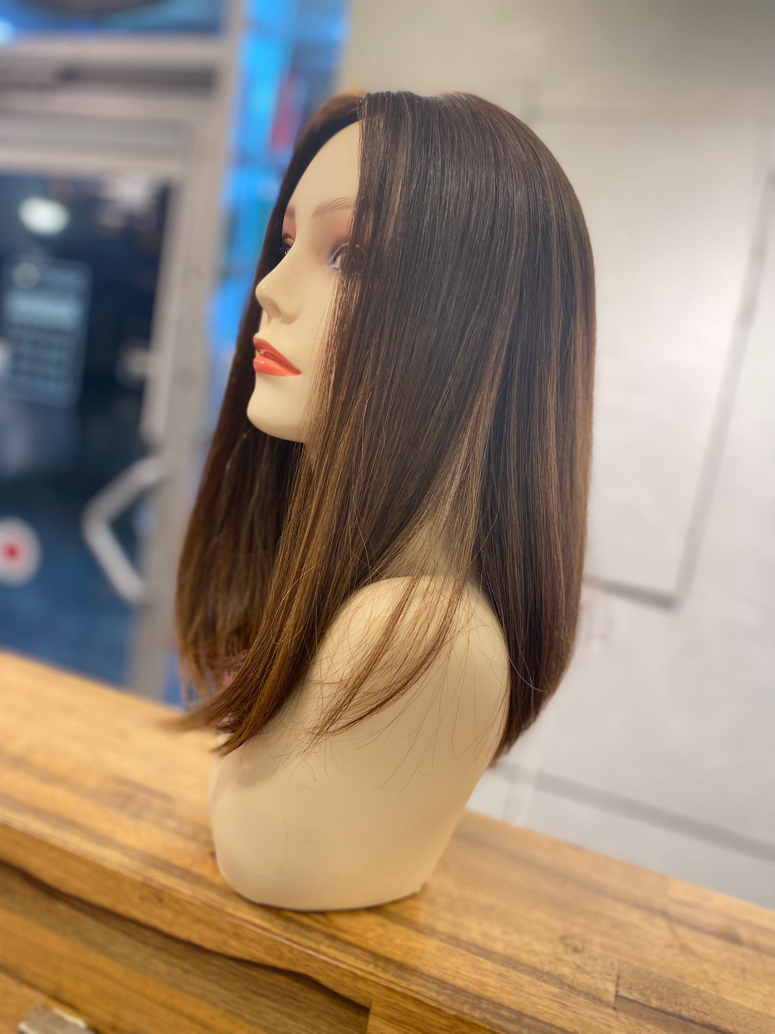 Une perruque longue et lisse en cheveux naturels sur une tête de présentation